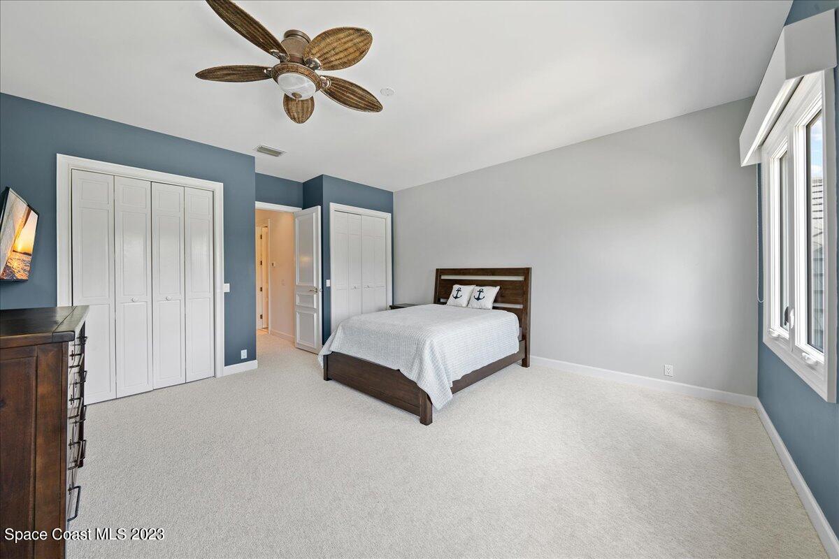 2815 Turtle Mound Road Melbourne, FL 32934 - Photo 65 of 115 a bedroom with a large bed and a chandelier