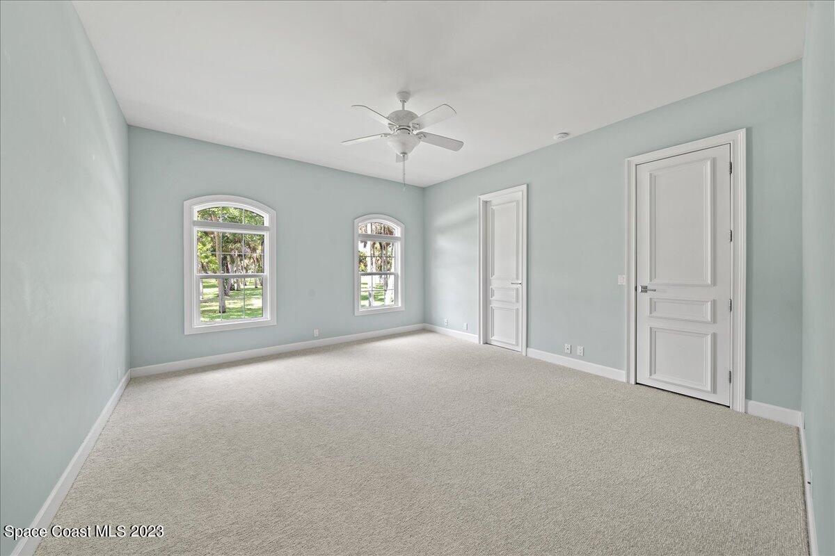 2815 Turtle Mound Road Melbourne, FL 32934 - Photo 74 of 115 an empty room with windows and ceiling fan