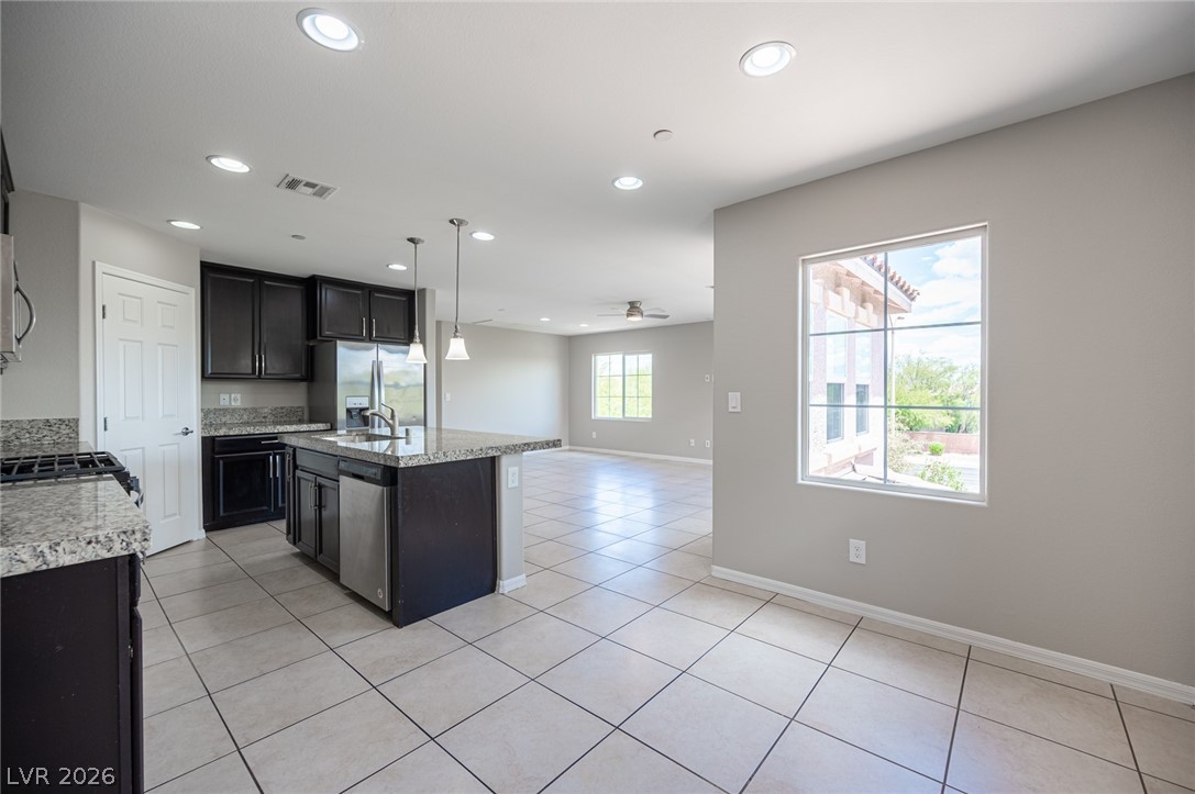 9916 Sable Point Street Las Vegas, NV 89178 - Photo 41 of 73 An open concept kitchen features abundant counter space and durable tile flooring, flowing seamlessly into the living area.