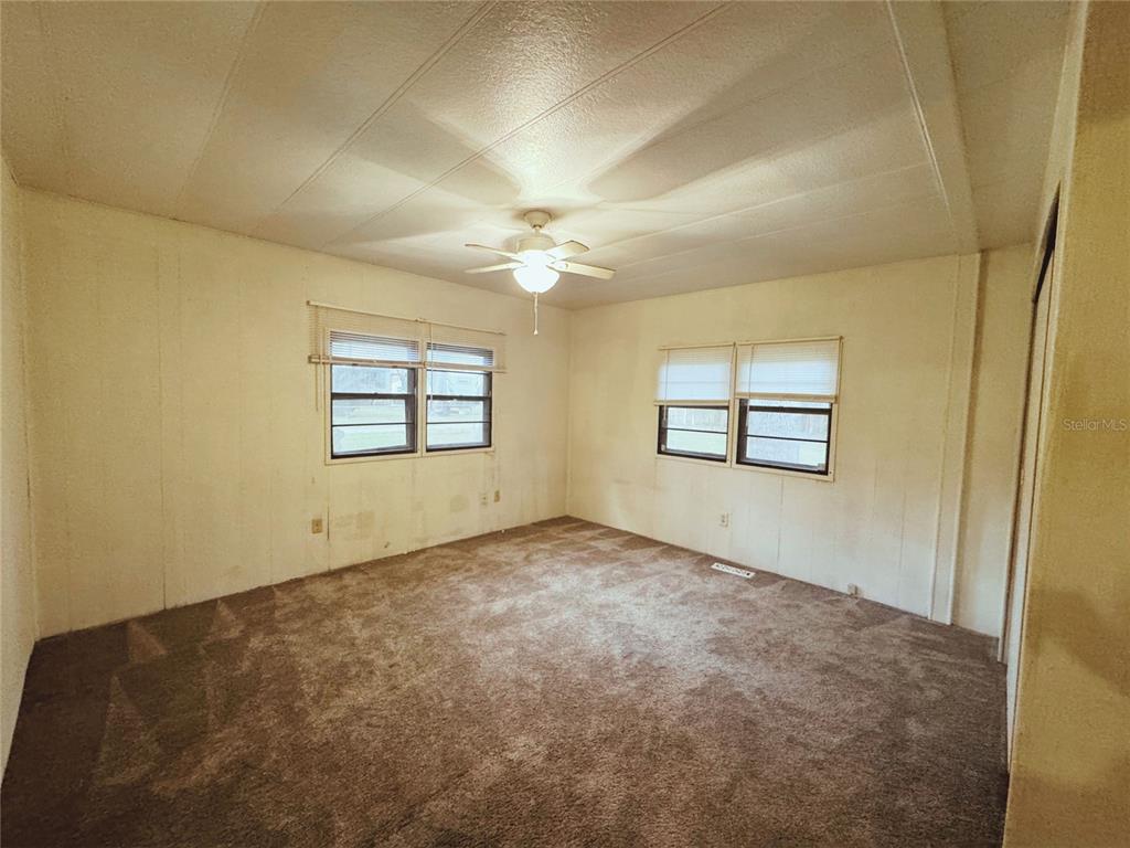 18395 Northwest 4th Terrace Citra, FL 32113 - Photo 30 of 66 an empty room with windows and ceiling fan