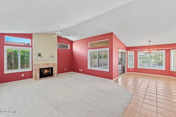 a view of an empty room with window and fire place