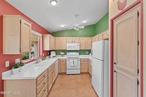 a kitchen with a sink refrigerator and cabinets