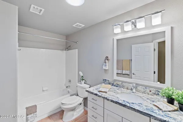 a bathroom with a granite countertop sink toilet a large mirror and shower