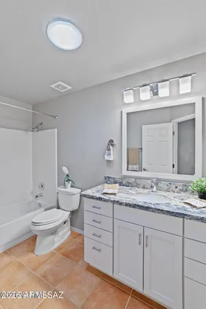 a bathroom with a granite countertop sink a toilet and a mirror