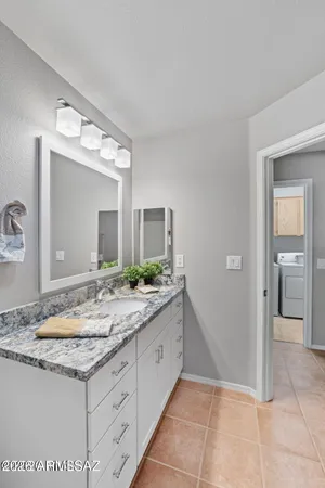 a bathroom with a granite countertop sink and a mirror