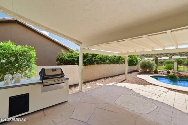 a view of a patio with table and chairs a barbeque with wooden fence