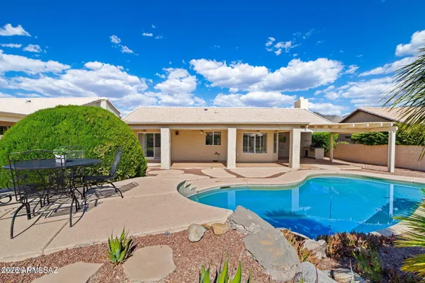 a view of a house with swimming pool and sitting area