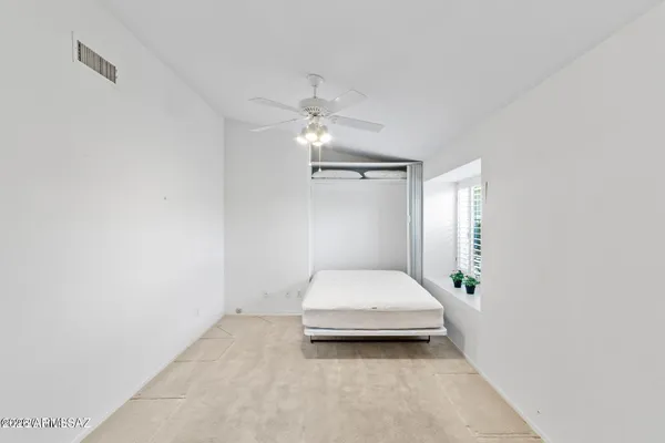 a bedroom with a bed and a ceiling fan