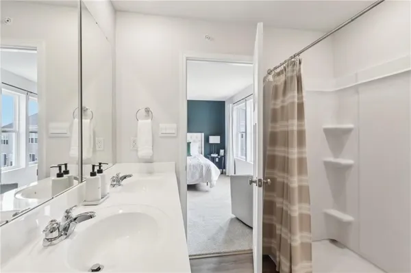 a en suite bathroom with a double vanity sink and mirror