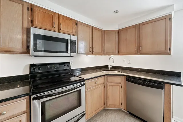 a kitchen with granite countertop cabinets and steel stainless steel appliances