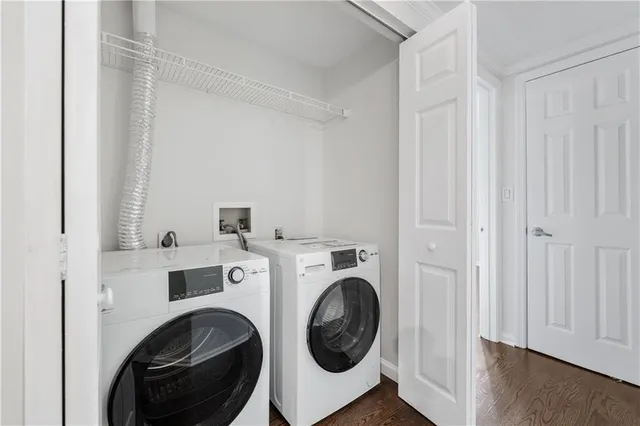 a utility room with dryer washer and a view of bedroom