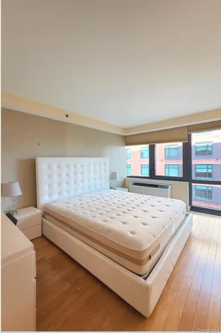 a bedroom with a bed and wooden floor