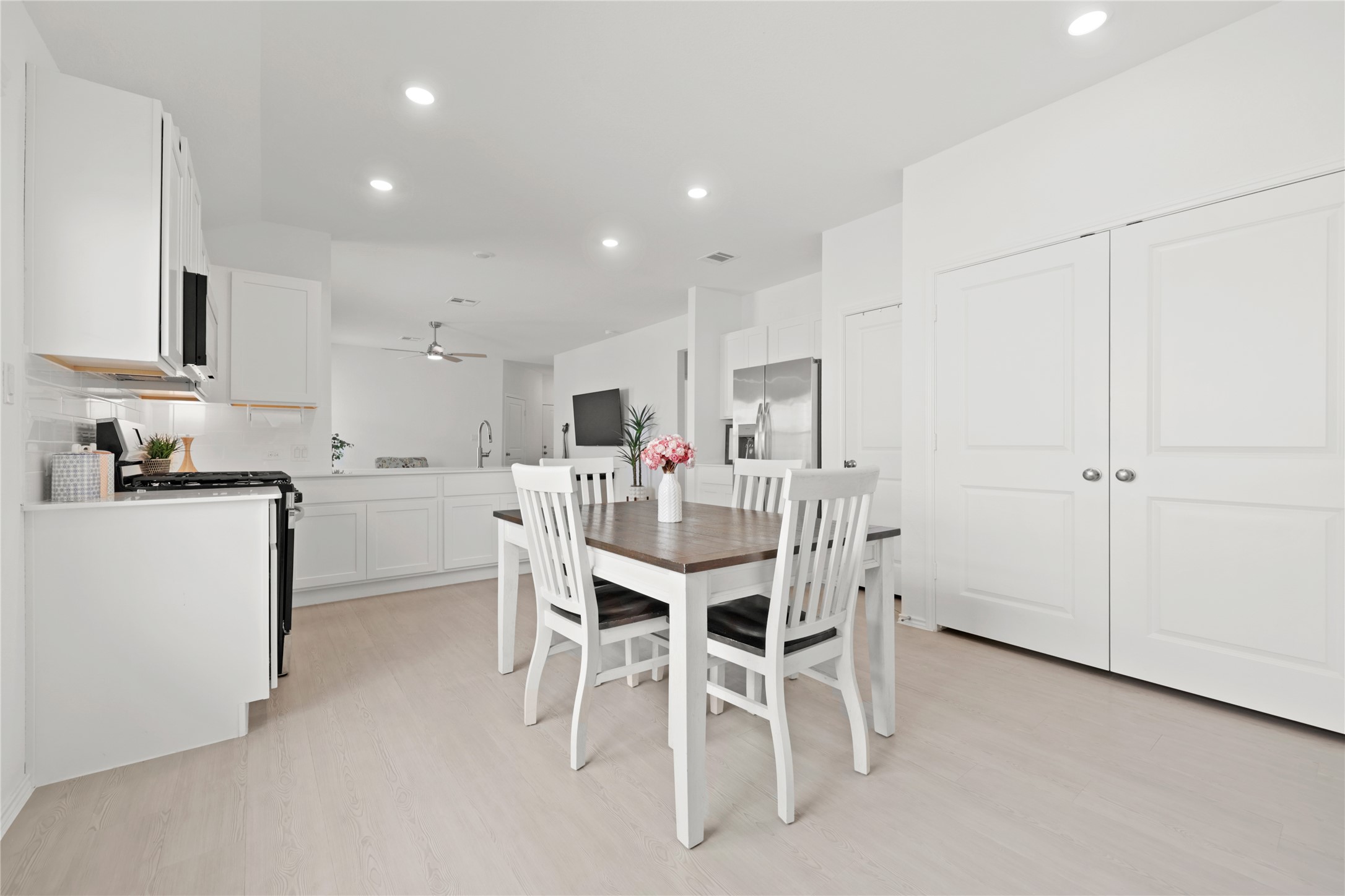 1073 Soapstone Pass Maxwell, TX 78656 - Photo 10 of 28 a kitchen with a dining table chairs refrigerator and white cabinets