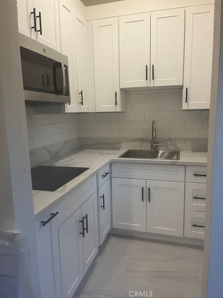a kitchen with stainless steel appliances granite countertop white cabinets a sink and dishwasher