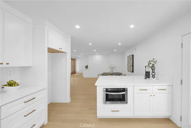 a kitchen with stainless steel appliances white cabinets and a refrigerator