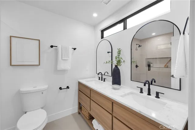 a bathroom with a double vanity sink mirror and toilet