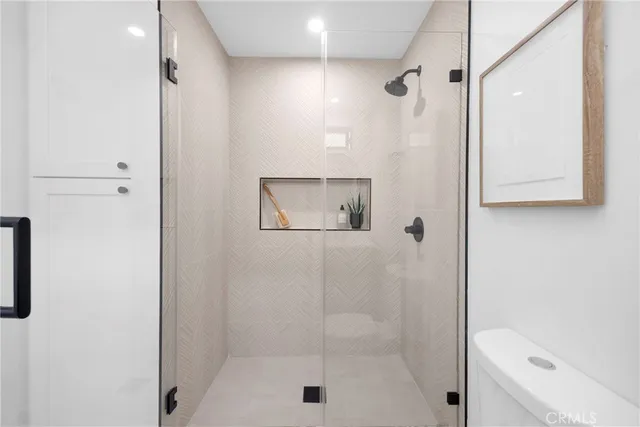 a bathroom with a granite countertop sink a toilet and shower