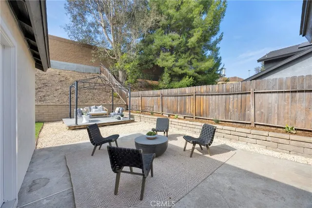 a view of a patio with a table and chairs under an umbrella