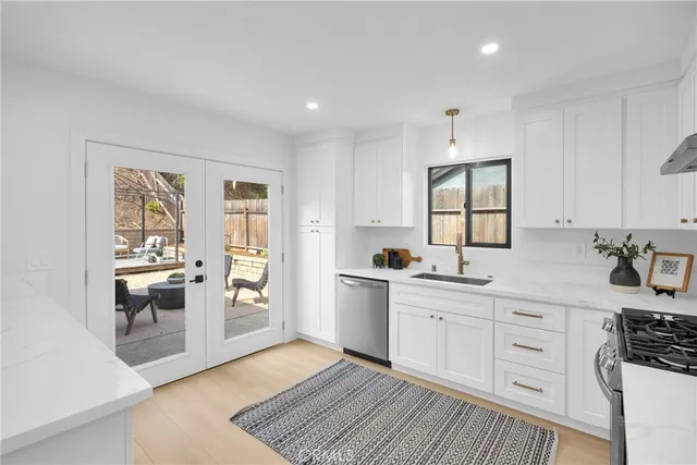 a kitchen with cabinets stainless steel appliances a sink and a window