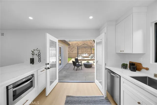 a kitchen with a sink and steel appliances