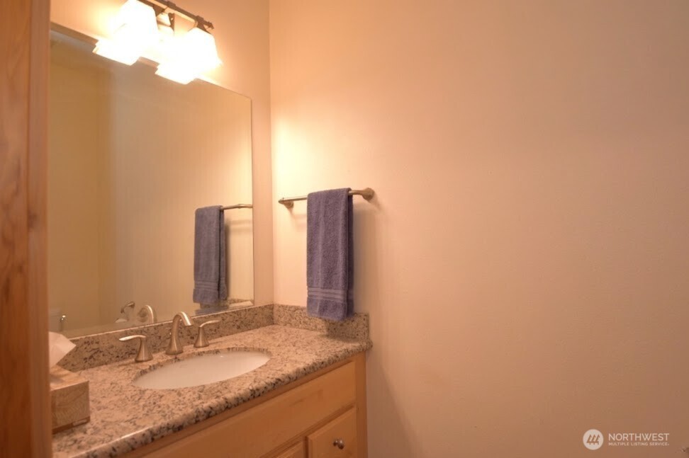 30333 Heimer Road Arlington, WA 98223 - Photo 24 of 40 a bathroom with a granite countertop sink and a mirror