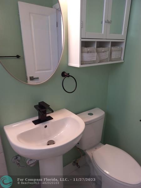 1861 Northeast 161st Street North Miami Beach, FL 33162 - Photo 13 of 32 a bathroom with a toilet sink and mirror