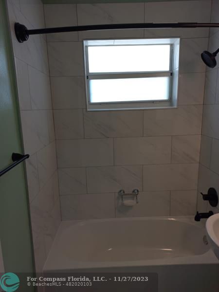 1861 Northeast 161st Street North Miami Beach, FL 33162 - Photo 14 of 32 a bath tub sitting next to a white sink and a vanity