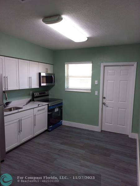 1861 Northeast 161st Street North Miami Beach, FL 33162 - Photo 15 of 32 a kitchen with granite countertop a stove a sink and a microwave