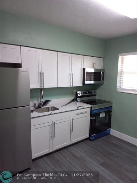 1861 Northeast 161st Street North Miami Beach, FL 33162 - Photo 16 of 32 a kitchen with a sink and a refrigerator