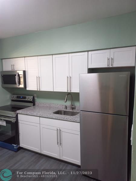 1861 Northeast 161st Street North Miami Beach, FL 33162 - Photo 28 of 32 a kitchen with appliances a sink and a refrigerator