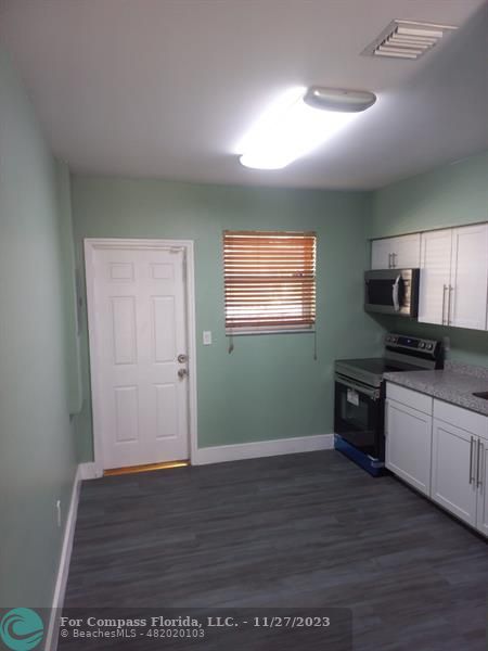 1861 Northeast 161st Street North Miami Beach, FL 33162 - Photo 29 of 32 a kitchen with granite countertop stainless steel appliances and wooden cabinets