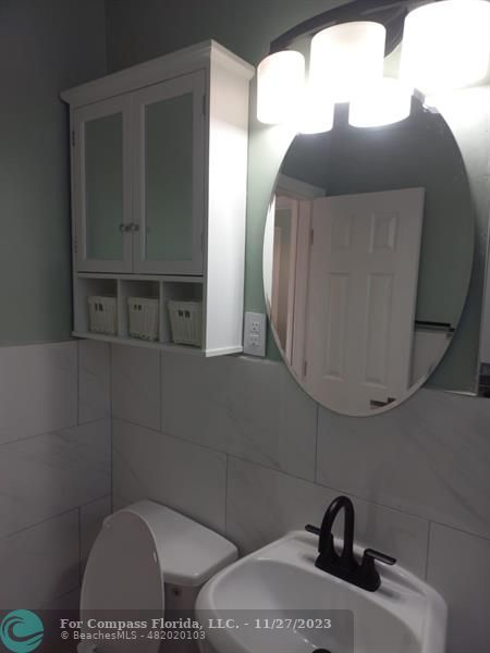 1861 Northeast 161st Street North Miami Beach, FL 33162 - Photo 30 of 32 a bathroom with a toilet sink and mirror
