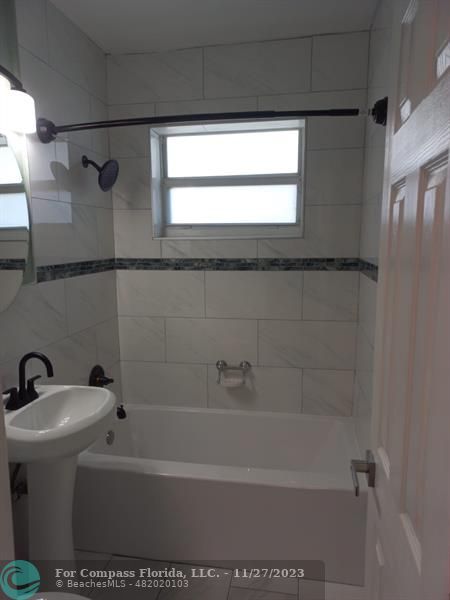 1861 Northeast 161st Street North Miami Beach, FL 33162 - Photo 31 of 32 a bath tub sitting next to a white sink and a shower