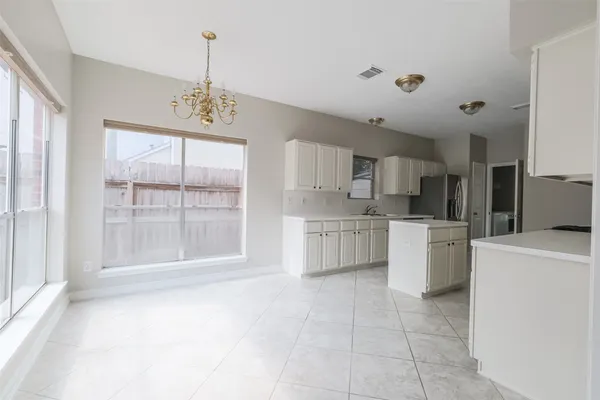 a kitchen with white cabinets and appliances