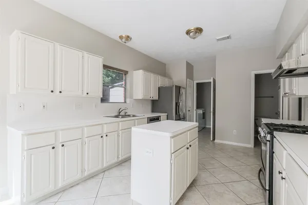 a kitchen with stainless steel appliances granite countertop a stove a sink and a refrigerator