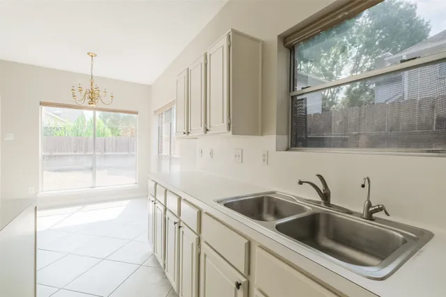 a kitchen with white cabinets and appliances