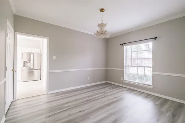 a view of a hallway with wooden floor and chandelier