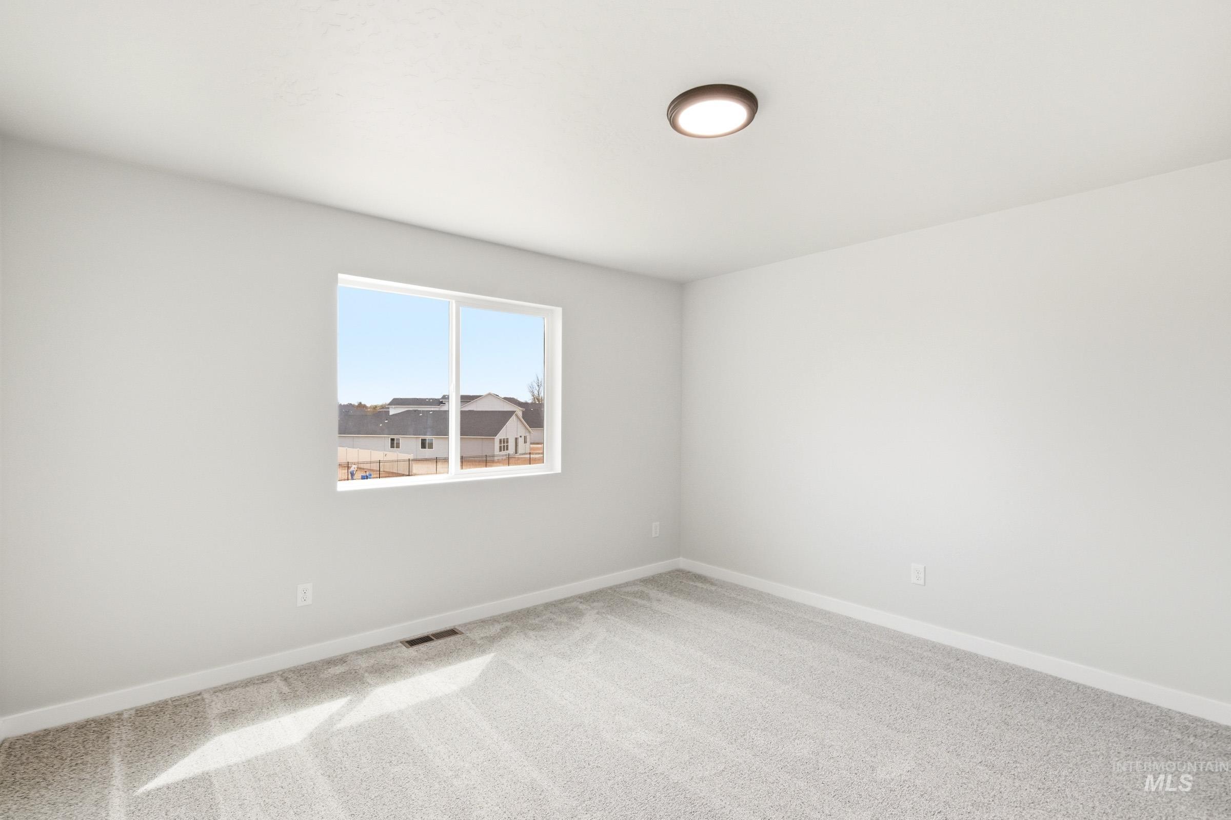 2446 West Fallon Loop Nampa, ID 83651 - Photo 14 of 19 Spare room featuring light carpet and baseboards