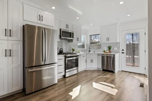 a kitchen with a refrigerator cabinets and wooden floor