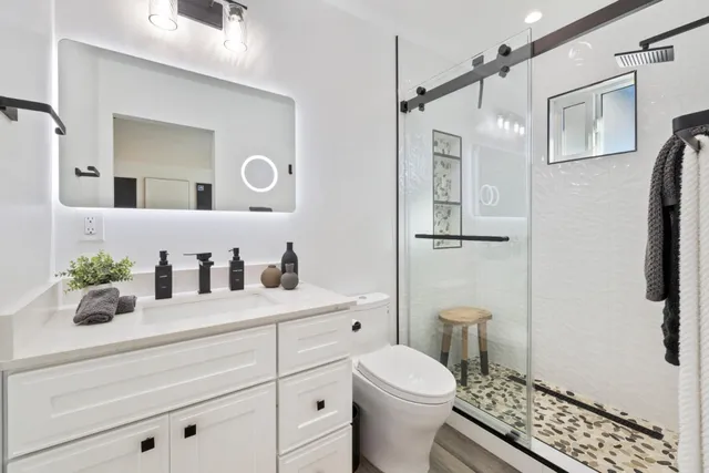 a bathroom with a sink a toilet and shower