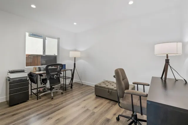 a view of a workspace with furniture and a window