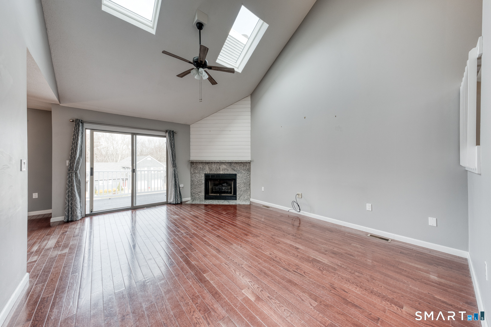 5 Vicki Lane, Unit 5 Colchester, CT 06415 - Photo 9 of 42 an empty room with wooden floor fireplace and windows