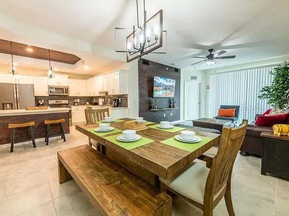 a kitchen with stainless steel appliances kitchen island granite countertop a table chairs sink and cabinets