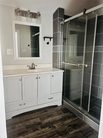 a bathroom with a sink a toilet a mirror and shower