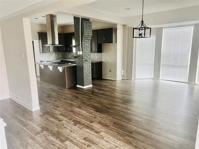 a kitchen with stainless steel appliances kitchen island granite countertop a refrigerator and a stove top oven