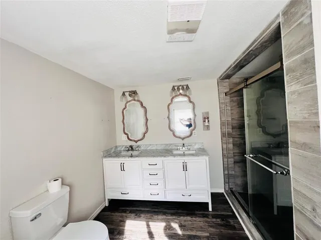 a bathroom with a granite countertop toilet sink and mirror