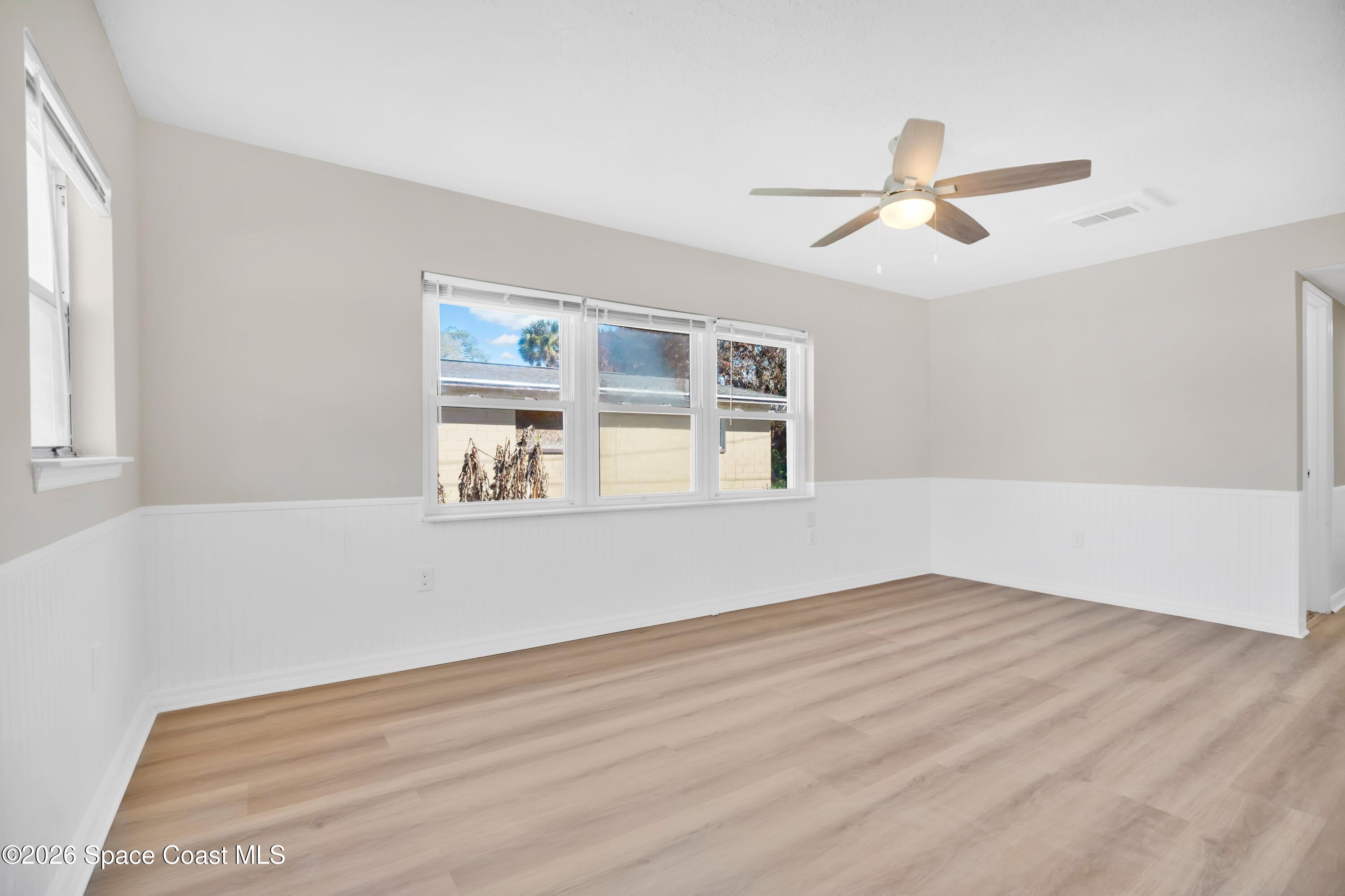 1215 Counts Street Cocoa, FL 32922 - Photo 3 of 25 a view of an empty room with wooden floor and a window