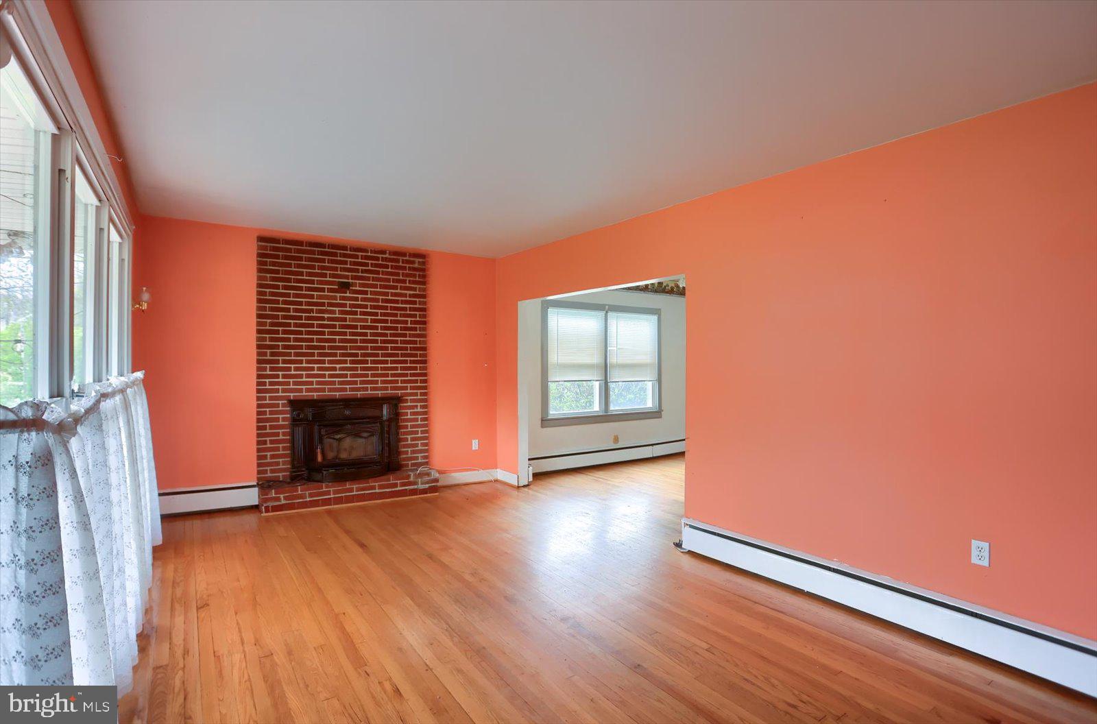 2301 Snow Road Edgewood, MD 21040 - Photo 5 of 41 an empty room with wooden floor fireplace and windows