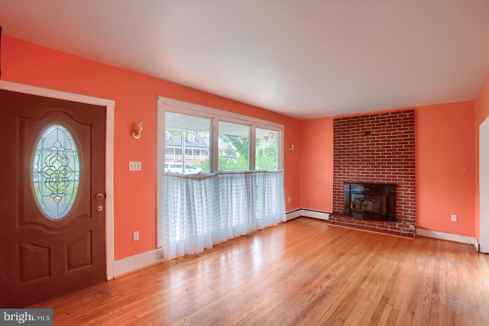 2301 Snow Road Edgewood, MD 21040 - Photo 6 of 41 an empty room with windows wooden floor and fireplace