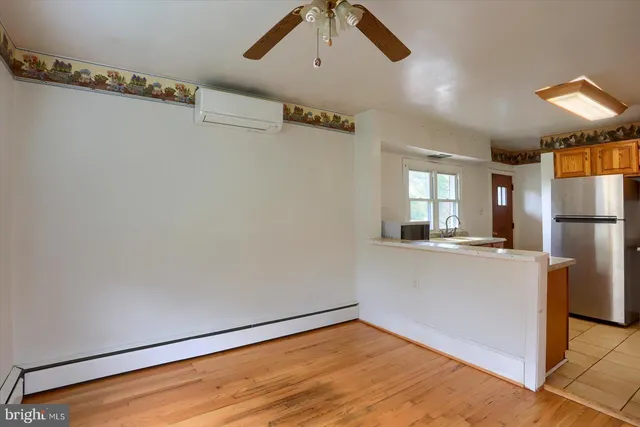 a view of a livingroom with a ceiling fan and wooden floor